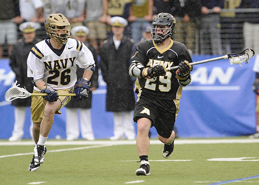 Army and Navy lacrosse midfielders running down the field